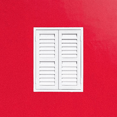 White window shutters on bright red wall
